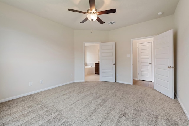 unfurnished bedroom with ceiling fan, light colored carpet, and ensuite bath