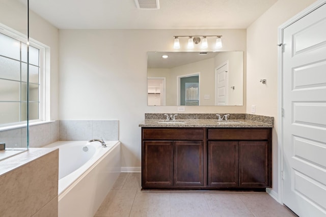 bathroom featuring vanity, tile patterned floors, and a tub