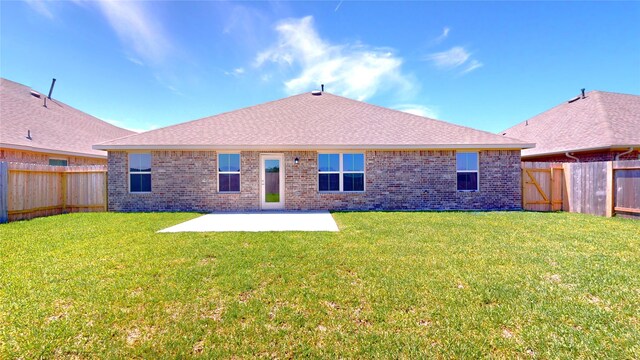 rear view of property featuring a lawn and a patio