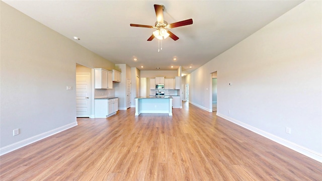 unfurnished living room with ceiling fan and light hardwood / wood-style floors