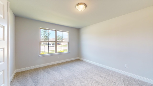 unfurnished room featuring light carpet