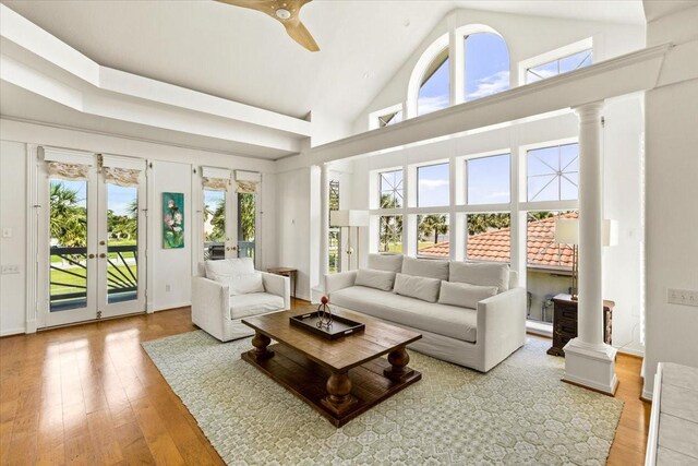 living room with french doors, high vaulted ceiling, light wood-type flooring, and plenty of natural light