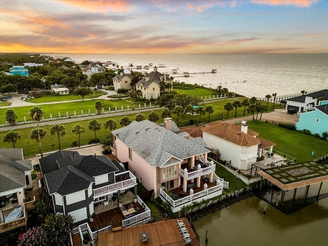 aerial view at dusk featuring a water view