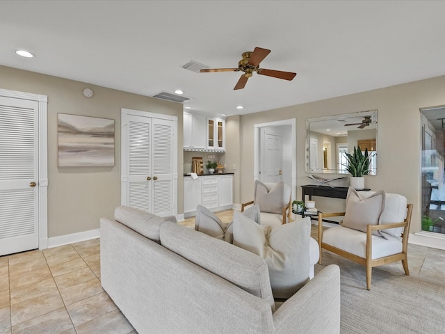 living room featuring indoor bar, light tile patterned floors, and ceiling fan