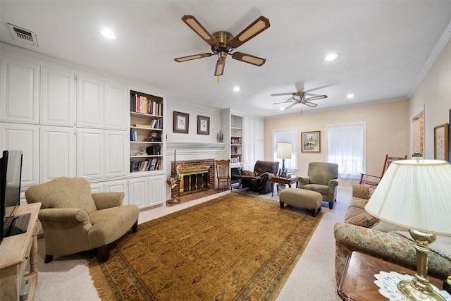 carpeted living room featuring ceiling fan, built in features, ornamental molding, and a fireplace