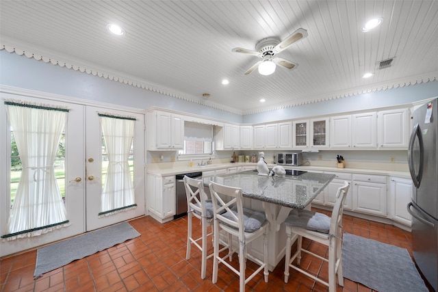 kitchen with a kitchen island, white cabinets, stainless steel appliances, and french doors