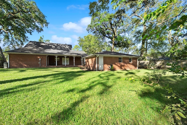 rear view of house featuring a lawn