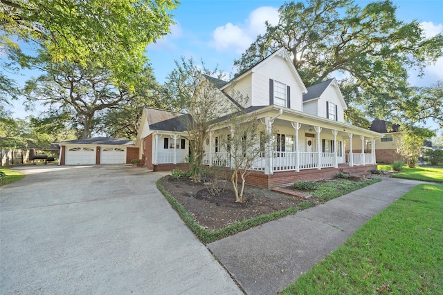 view of front of house with covered porch, a front yard, and a garage