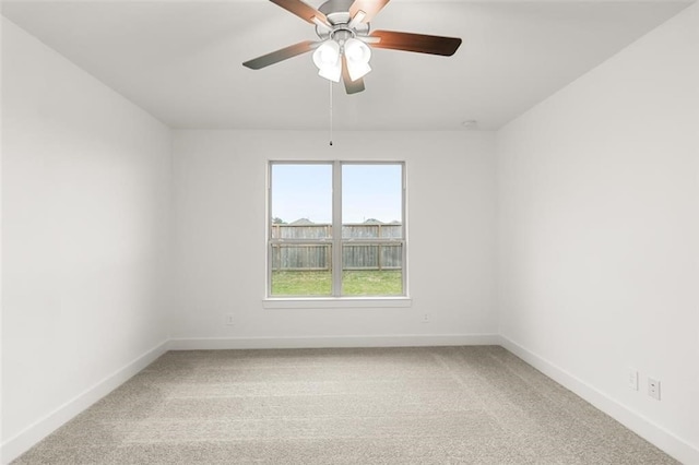 spare room featuring a ceiling fan, baseboards, and light colored carpet