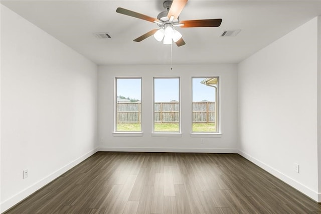 unfurnished room with dark wood finished floors, baseboards, ceiling fan, and visible vents
