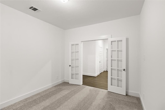 unfurnished bedroom with carpet floors, visible vents, baseboards, and french doors