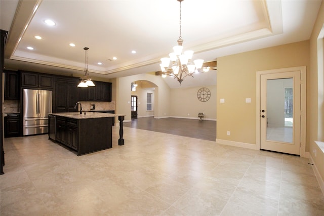 kitchen featuring backsplash, stainless steel refrigerator, and a raised ceiling