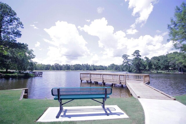 dock area with a lawn and a water view