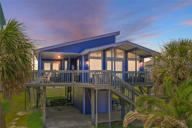 back house at dusk featuring a carport