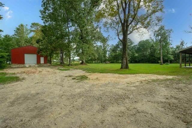 view of yard featuring an outdoor structure and a garage