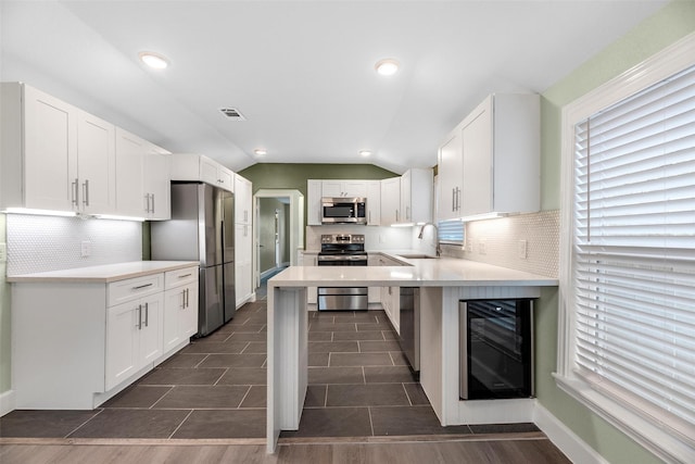 kitchen featuring white cabinetry, vaulted ceiling, and appliances with stainless steel finishes