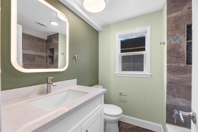 bathroom with tile patterned floors, toilet, vanity, and tiled shower