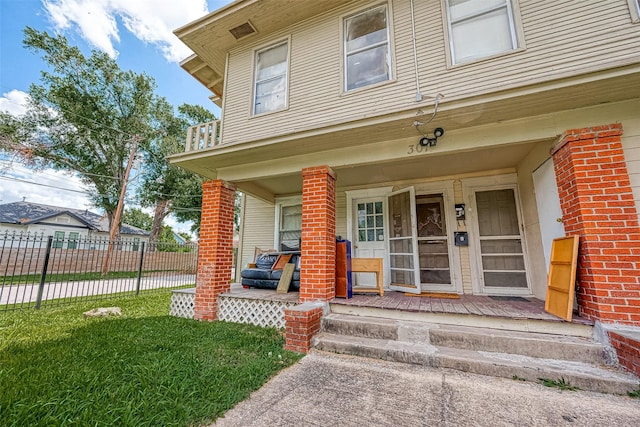 property entrance with a porch and a yard