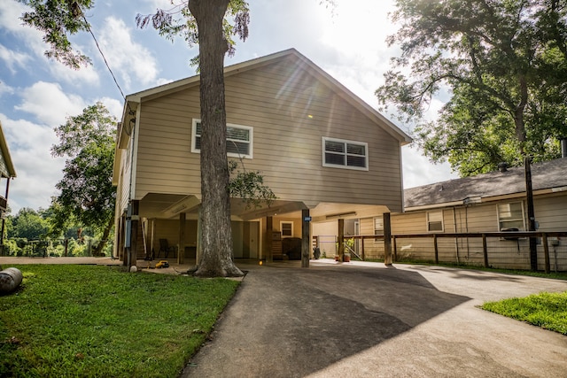 rear view of property featuring a yard and a carport