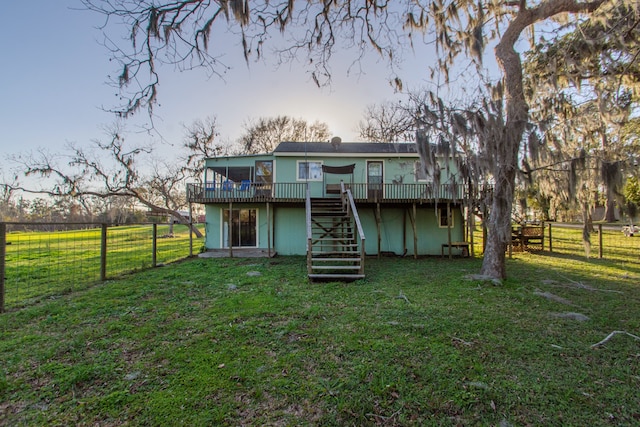 back of property featuring a wooden deck and a lawn