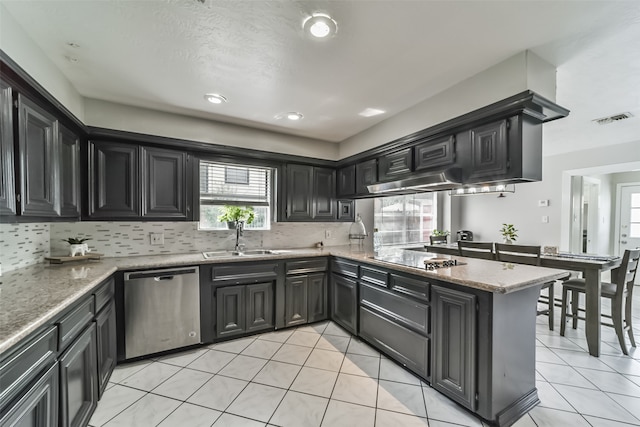 kitchen with dishwasher, black electric cooktop, light tile flooring, light stone counters, and sink