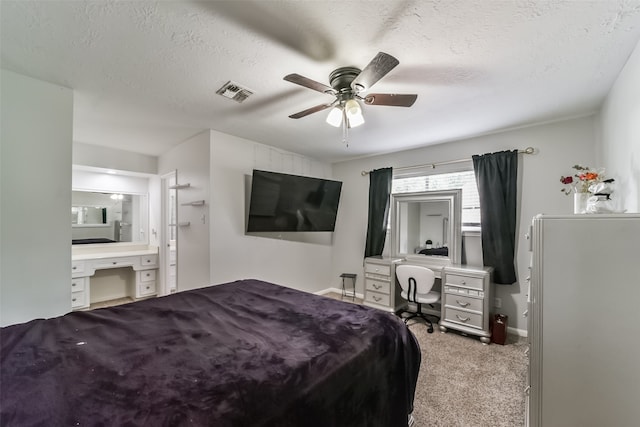 carpeted bedroom with ceiling fan, a textured ceiling, and ensuite bathroom