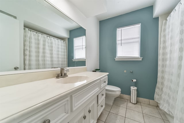 bathroom with tile flooring, a healthy amount of sunlight, toilet, and vanity