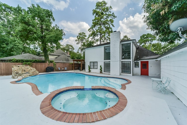 view of pool with a patio area and an in ground hot tub