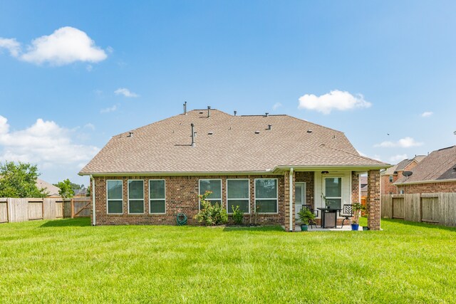 rear view of property featuring a patio and a yard