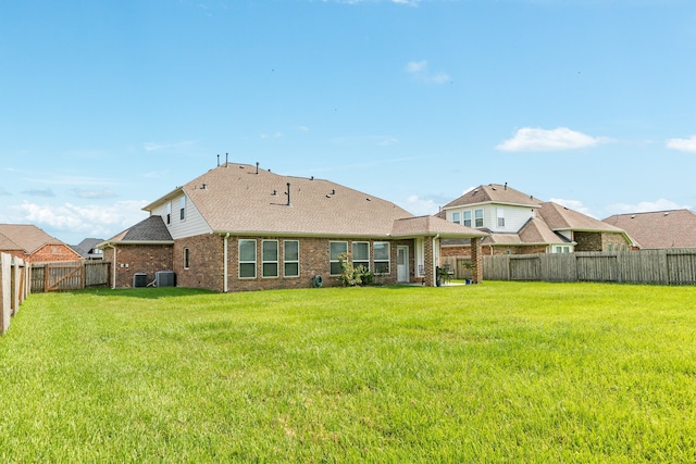 back of property featuring central AC unit and a lawn