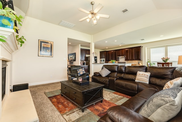 carpeted living room with ceiling fan