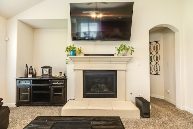 carpeted living room featuring a tiled fireplace