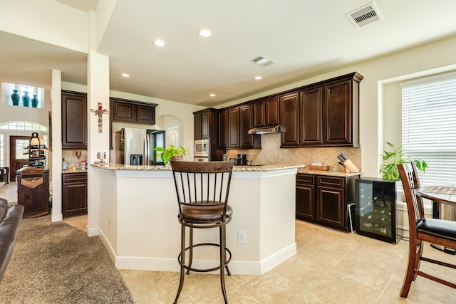 kitchen with stainless steel appliances, plenty of natural light, backsplash, and light tile floors