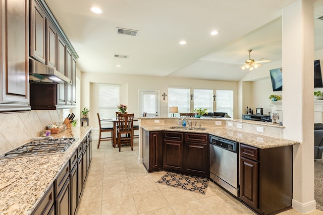 kitchen featuring appliances with stainless steel finishes, light stone counters, backsplash, ceiling fan, and light tile floors