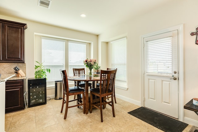 tiled dining room featuring plenty of natural light and wine cooler