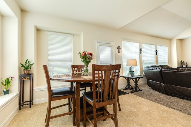 tiled dining room featuring lofted ceiling