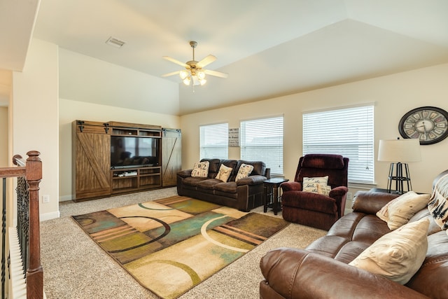 living room with a wealth of natural light, vaulted ceiling, carpet, and ceiling fan