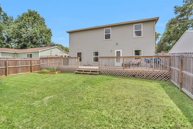 rear view of property with a deck and a lawn