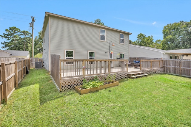 rear view of property with a yard, a deck, and central air condition unit