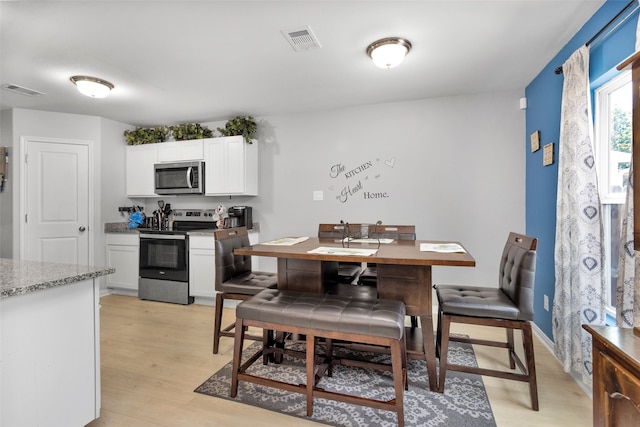 dining space with light hardwood / wood-style floors