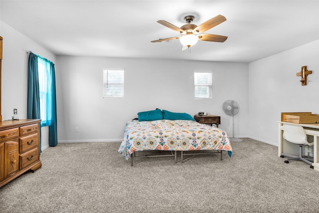 carpeted bedroom featuring ceiling fan and multiple windows