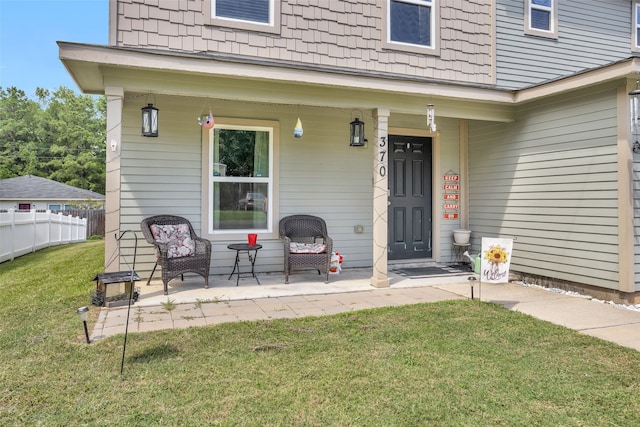 entrance to property with a yard and covered porch