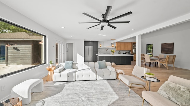 living room featuring ceiling fan, a healthy amount of sunlight, and light hardwood / wood-style flooring