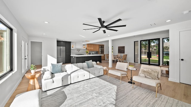 living room featuring ceiling fan and light hardwood / wood-style flooring