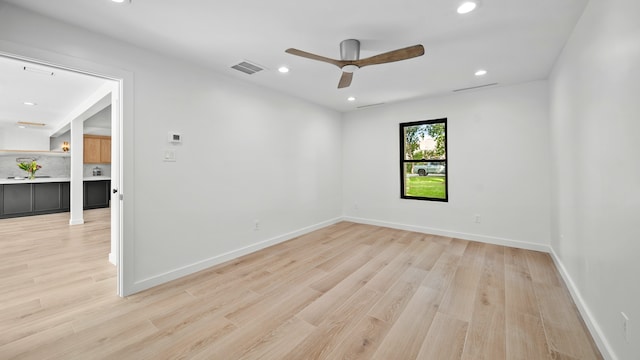 unfurnished room with ceiling fan and light hardwood / wood-style floors