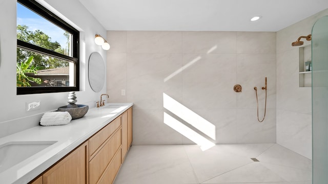 bathroom with tile patterned flooring, a shower, and vanity