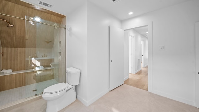 bathroom with hardwood / wood-style flooring, toilet, and a shower with shower door