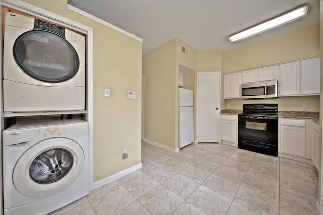 washroom with stacked washer / dryer and light tile floors