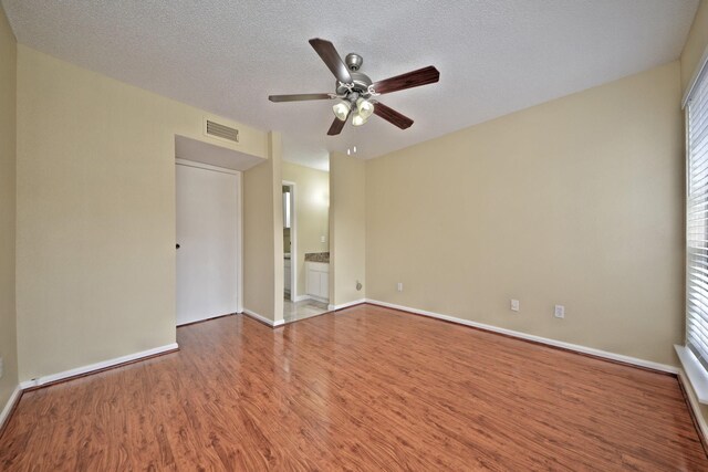 spare room featuring a textured ceiling, ceiling fan, and hardwood / wood-style floors