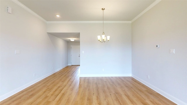 empty room featuring a notable chandelier, light hardwood / wood-style flooring, and crown molding